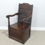 An antique probably 17th century oak wainscot box seat Armchair, carved backrest flanked by scrolled
