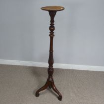 A Victorian mahogany Torchere / plant Stand, circular top raised on turned and foliate carved column