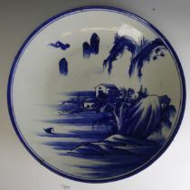 An antique Japanese Arita porcelain Charger, un underglaze blue and white depiction of mountains,