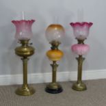 A Victorian Youngs brass Oil lamp, cranberry and etched glass shade raised on brass reservoir and
