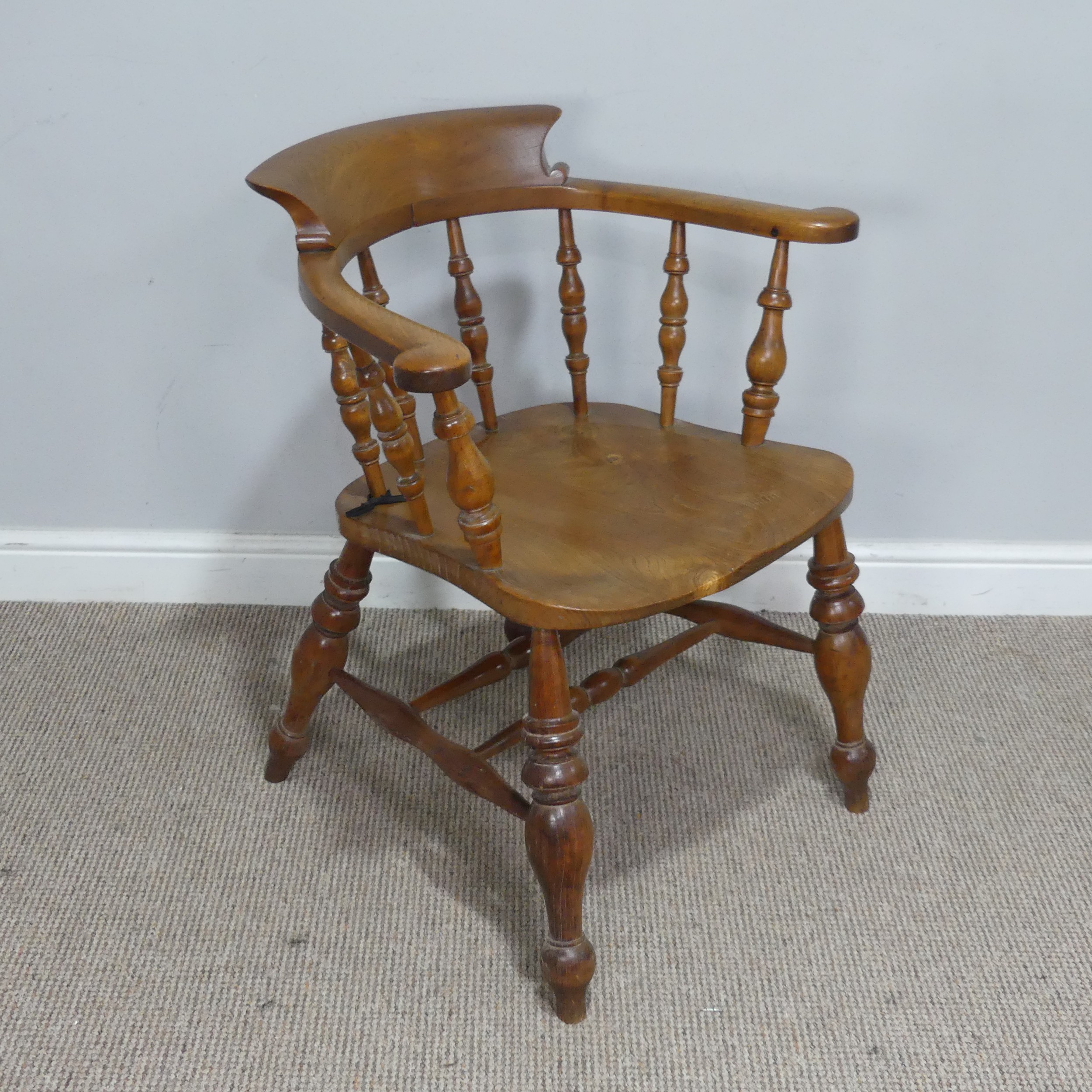 An early 20th century ash and elm Captains / Smokers Bow Armchair, W 66 cm x H 77 cm x D 60 cm.