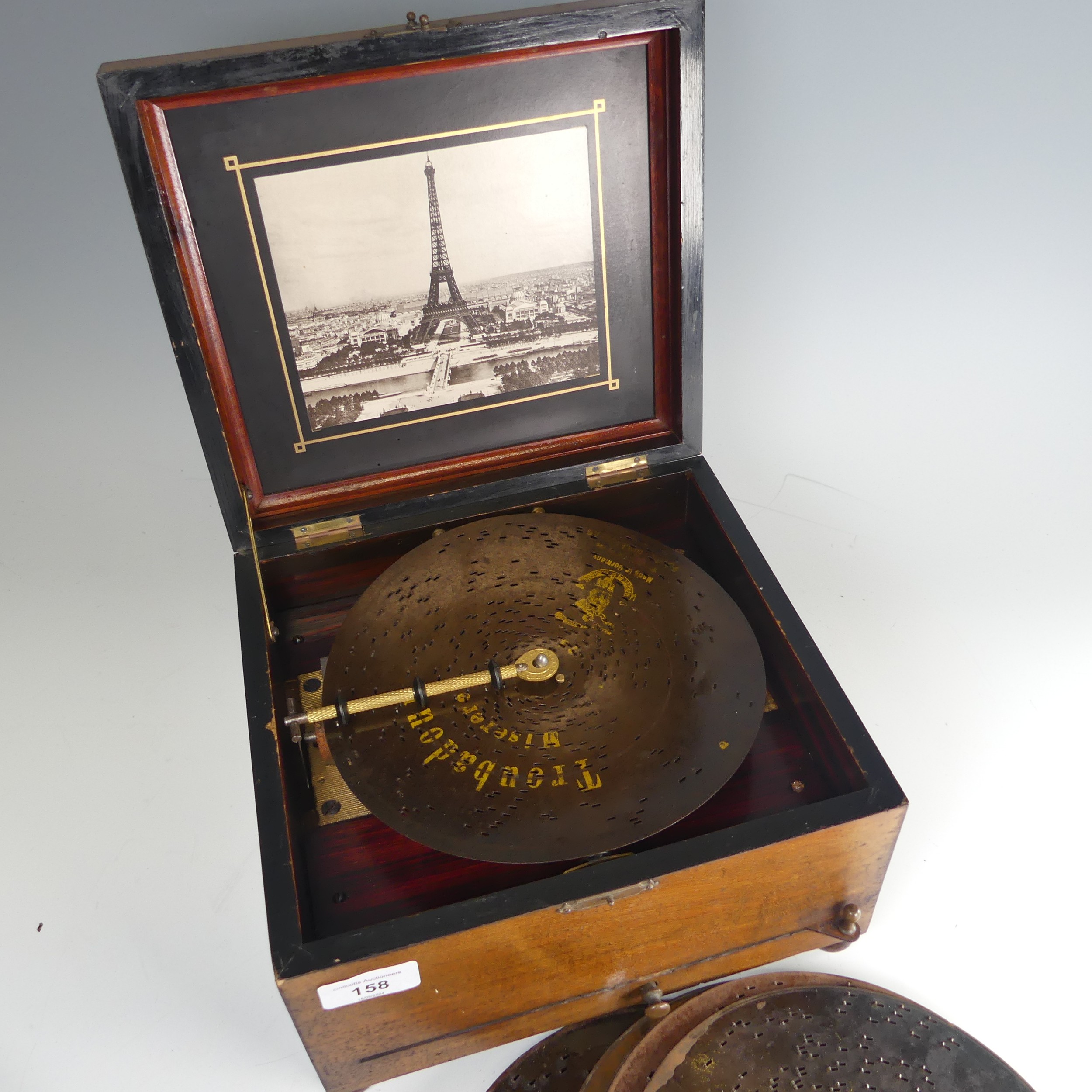 A late 19th century walnut cased Polyphon, with decorative hinged lid, the inside lid with