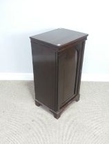 An antique mahogany Pot Cupboard, squared top over cupboard door concealing two shelves, raised on