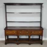 A George III oak Dresser Base, with associated plate rack, the moulded cornice inset with hooks