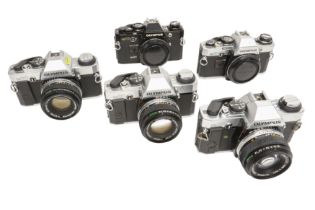 Five Olympus OM cameras.