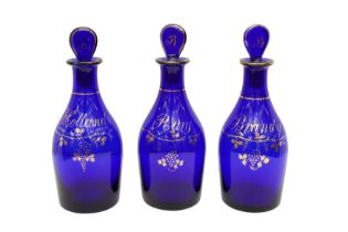 A SET OF THREE GEORGIAN BRISTOL BLUE GLASS DECANTERS