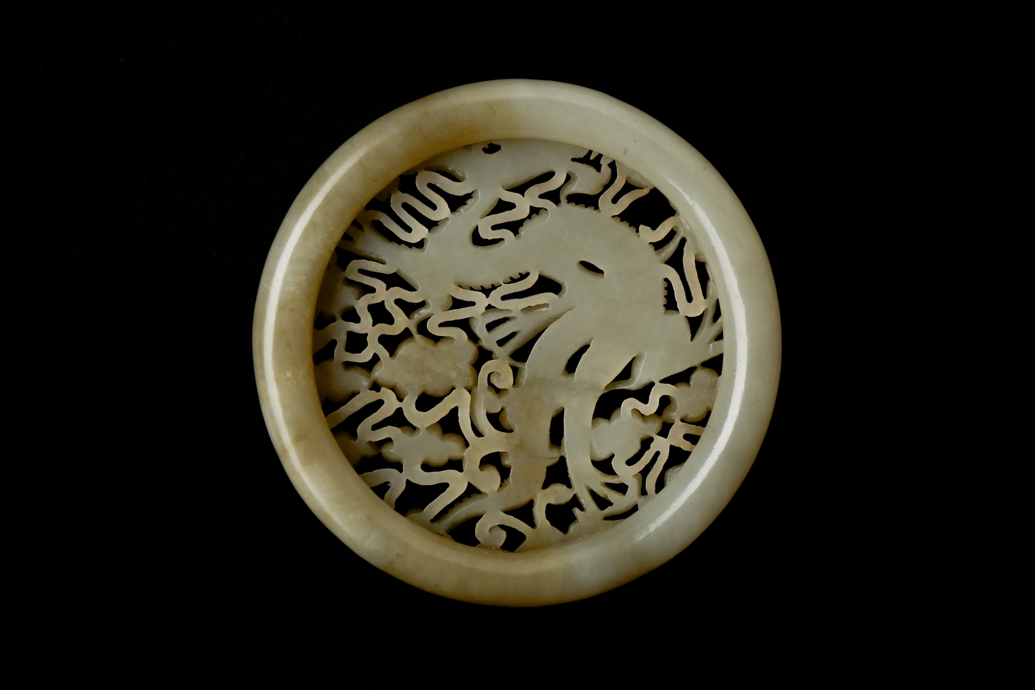 A CHINESE RETICULATED WHITE AND RUSSET JADE 'DRAGON' ROUND PLAQUE 十九世紀 白玉糖色龍趕珠紋珮 - Image 2 of 10