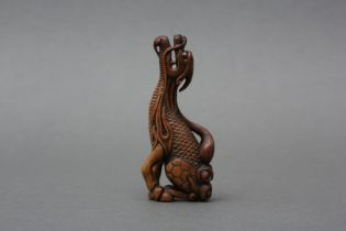 A JAPANESE BOXWOOD NETSUKE OF A MYTHICAL KIRIN, AFTER TOMOTADA