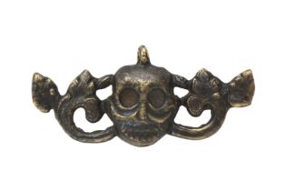 A SMALL HIMALAYAN BRONZE 'SKULL' AMULET