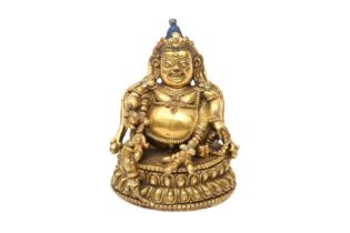 A FINE TIBETAN GILT-BRONZE SMALL FIGURE OF KUBERA 十五世紀 銅鎏金俱毗羅坐像