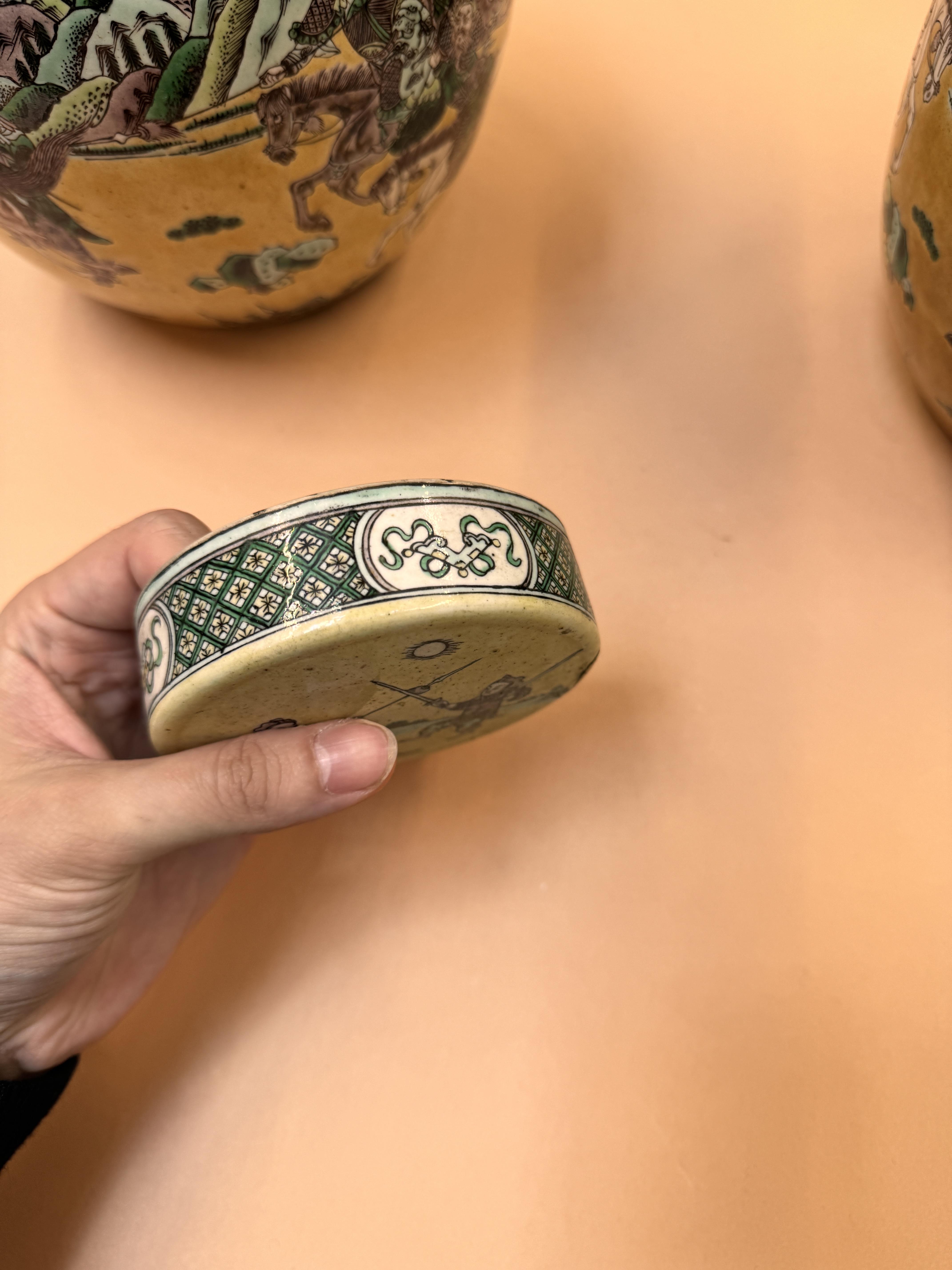 A PAIR OF CHINESE FAMILLE-JAUNE JARS AND COVERS 清十九世紀 三彩勇戰圖紋蓋罐一對 - Image 11 of 37