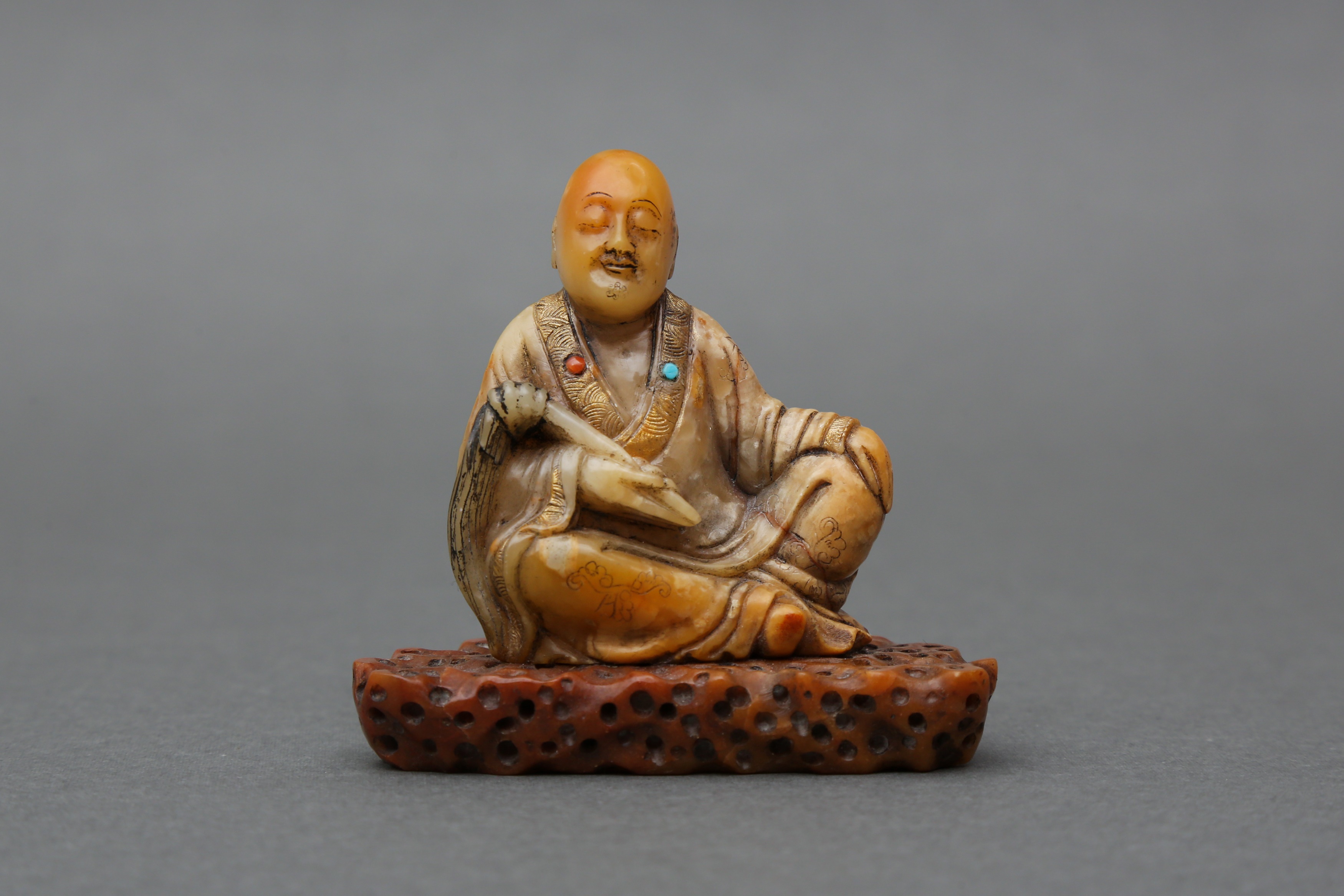 A FINE CHINESE SOAPSTONE FIGURE OF A SEATED LOUHAN, ATTRIBUTED TO ZHOU BIN 十七至十八世紀 傳周彬製 壽山石羅漢臥像擺件 《尚