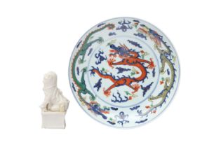 A CHINESE WUCAI 'DRAGONS' DISH AND A DEHUA FIGURE 十八至二十世紀 五彩飛龍趕珠紋盤及德化白釉佛獅 《大明嘉靖年製》款