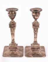 A pair of Edwardian silver candlesticks,