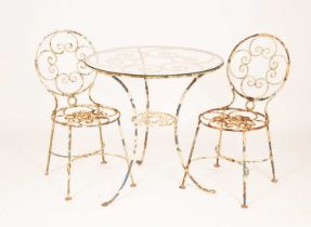 A pair of white painted metal garden chairs and a matching table