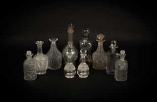 A group of ten cut glass decanters and some stoppers