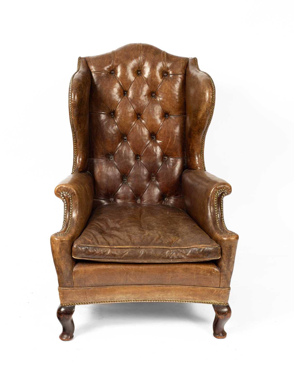 An early 20th Century leather wingback chair