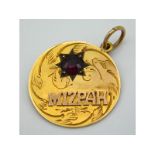 A 9ct gold Mizpah pendant set with garnet, 20mm di