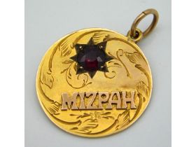A 9ct gold Mizpah pendant set with garnet, 20mm di