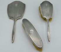 A 1904 Birmingham silver mounted mirror & brush set twinned with a Chester silver mounted clothes br