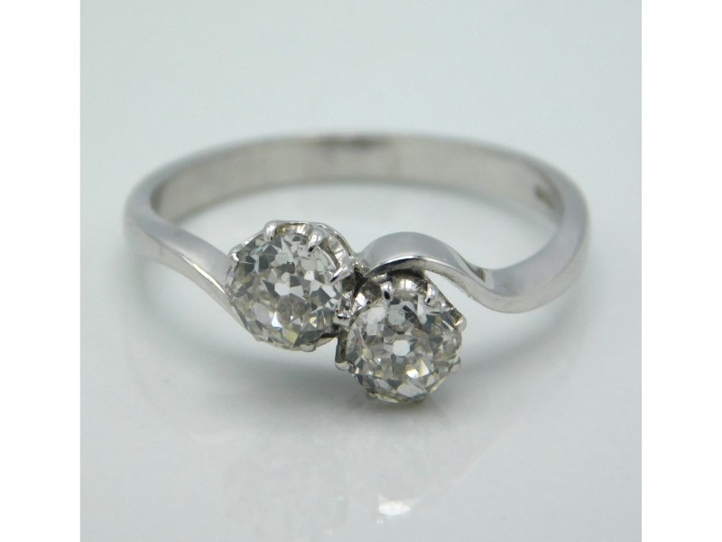 An 18ct white gold crossover ring set with two old