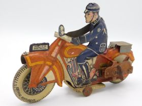 A vintage clockwork tin plate police motorcyclist,