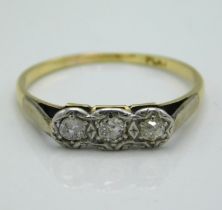 A yellow metal three stone platinum mounted diamond ring, tests electronically as 18ct gold, approx.