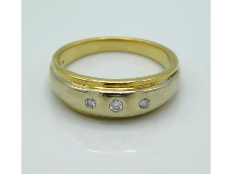 An 18ct gold ring set with three small diamonds, w