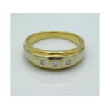 An 18ct gold ring set with three small diamonds, w