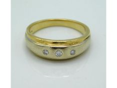 An 18ct gold ring set with three small diamonds, w