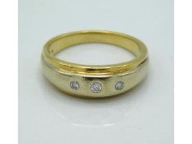 An 18ct gold ring set with three small diamonds, w