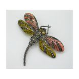 A detailed, silver dragonfly brooch set with marca
