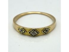 An antique yellow metal ring set with three small diamonds, tests electronically as 18ct gold, 1.8g,