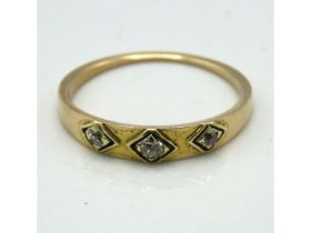 An antique yellow metal ring set with three small diamonds, tests electronically as 18ct gold, 1.8g,