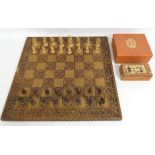 A large carved style chess board with pieces twinn