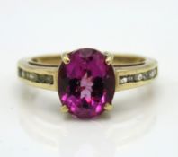 A 9ct gold ring set with pink sapphire & pave set