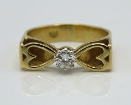 A yellow metal ring with heart shaped decor set wi