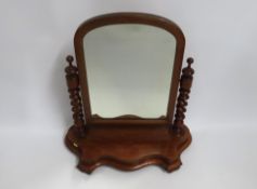 A Victorian walnut dressing table mirror with barl