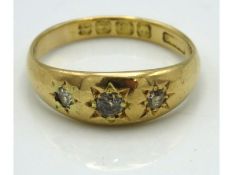 An 18ct gold ring set with three diamonds of appro