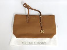 A leather Michael Kors bag with dust cover, presen
