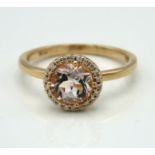 An 18ct rose gold halo ring set with diamond & mor