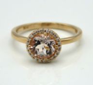 An 18ct rose gold halo ring set with diamond & mor