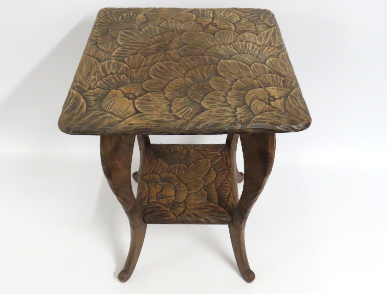 A carved fruitwood table of organic design with sh