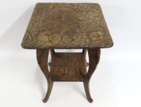 A carved fruitwood table of organic design with sh