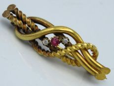 A yellow metal bar brooch set with diamond & ruby,