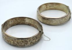Two silver bangles with chased decor, both have bu