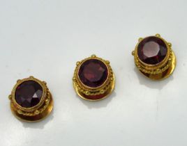 Three yellow metal collar studs set with garnet, w