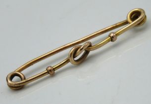 A yellow metal bar brooch, tests electronically as