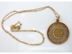 A 9ct gold chain 400mm long 0.4g twinned with a 14ct pendant 30mm diameter with Oriental script fron