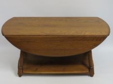 A Ercol elm 'Golden Dawn' low level drop leaf coffee table with shelf under, 1070mm wide x 930mm dee